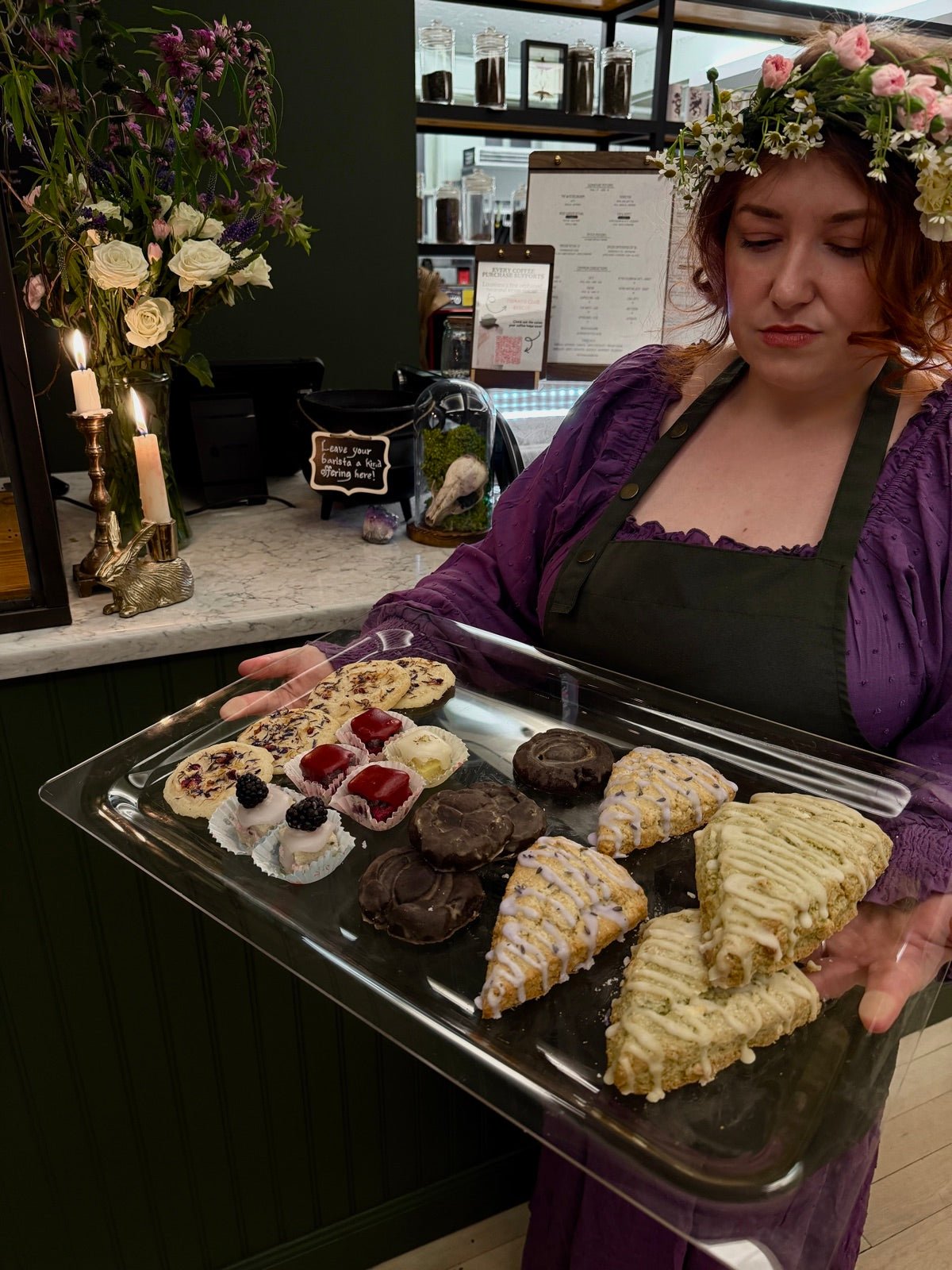 Deanna Holdcraft presenting a tray of house-baked scones, cookies, and petit fours at Witches Brew Coffee Co.