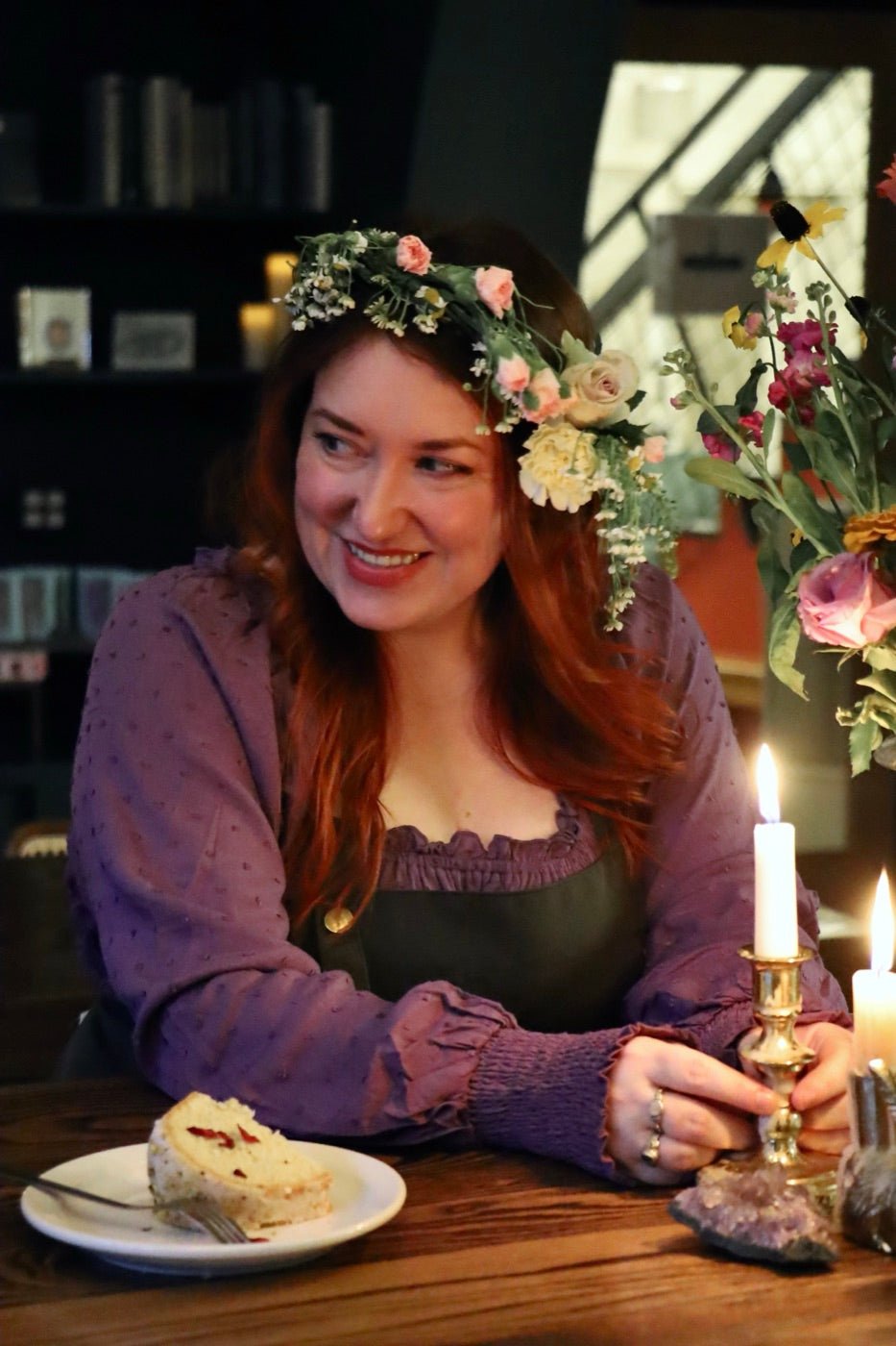 Deanna Holdcraft, co-owner and head baker of Witches Brew Coffee Co., in a flower crown at a candlelit table