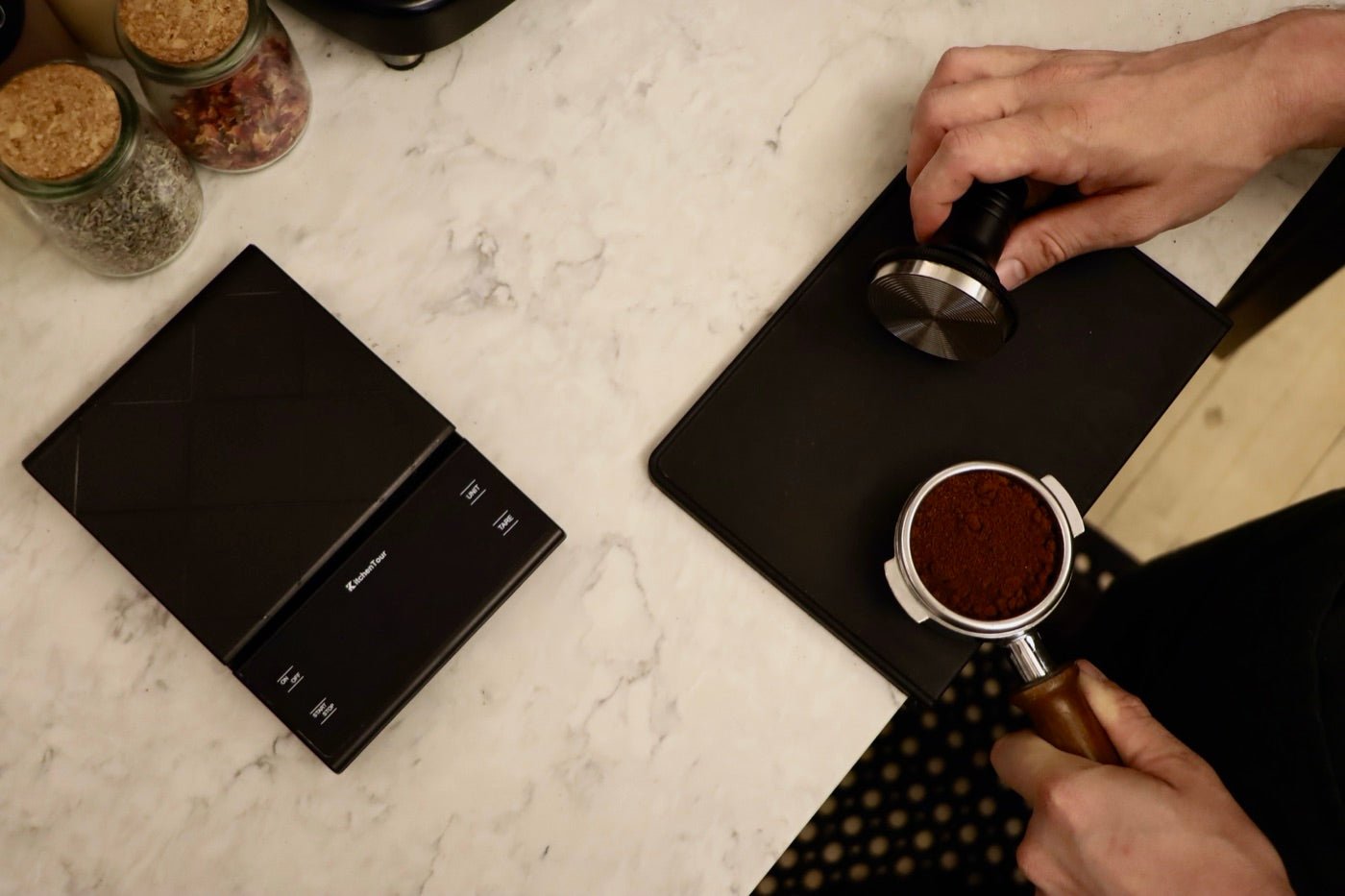 Overhead view of a barista tamping a dose of espresso beside a scale at Witches Brew Coffee Co. in New Orleans