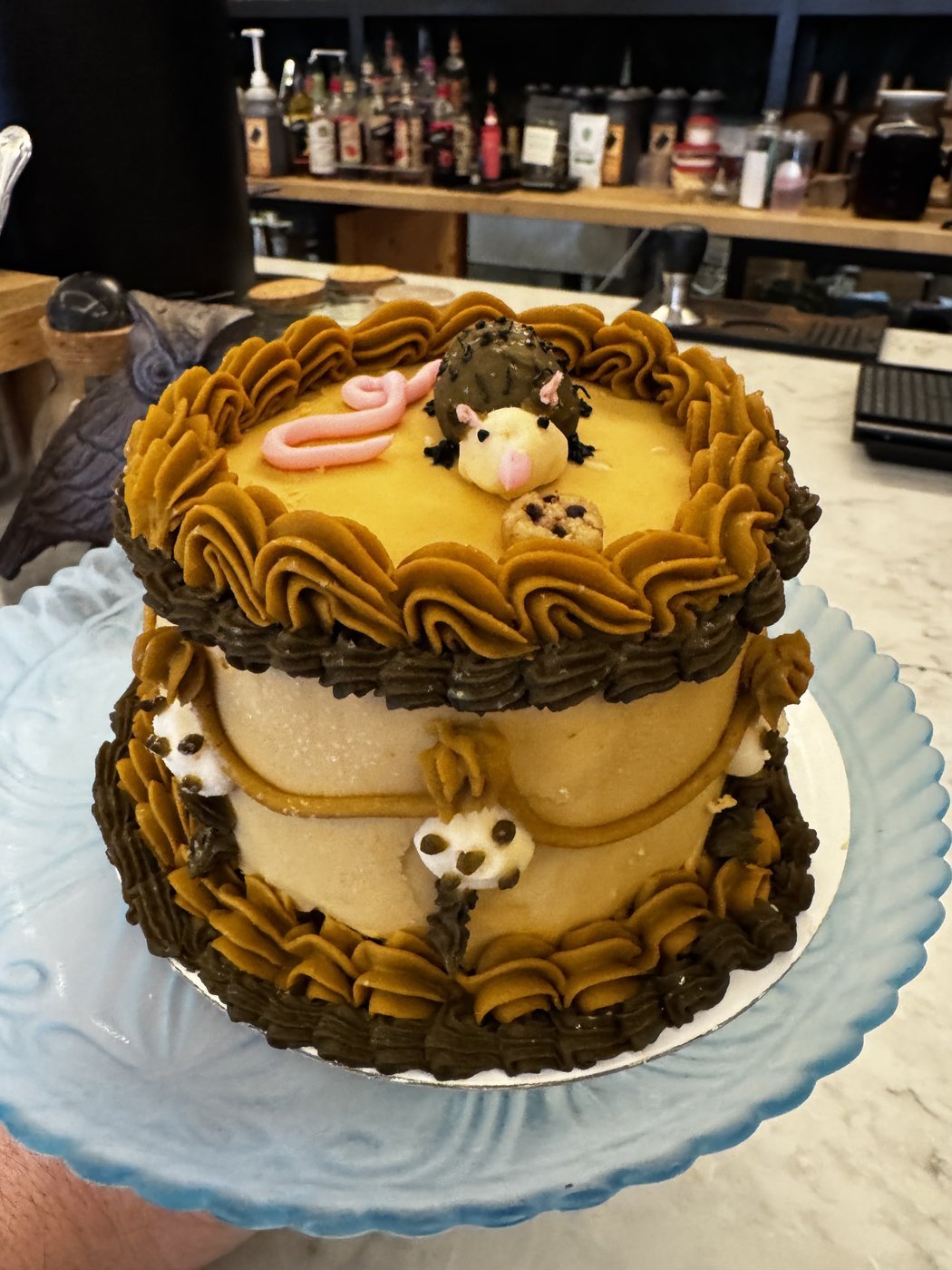 A birthday commission: piped vintage-style cake with a small sculpted opossum on top